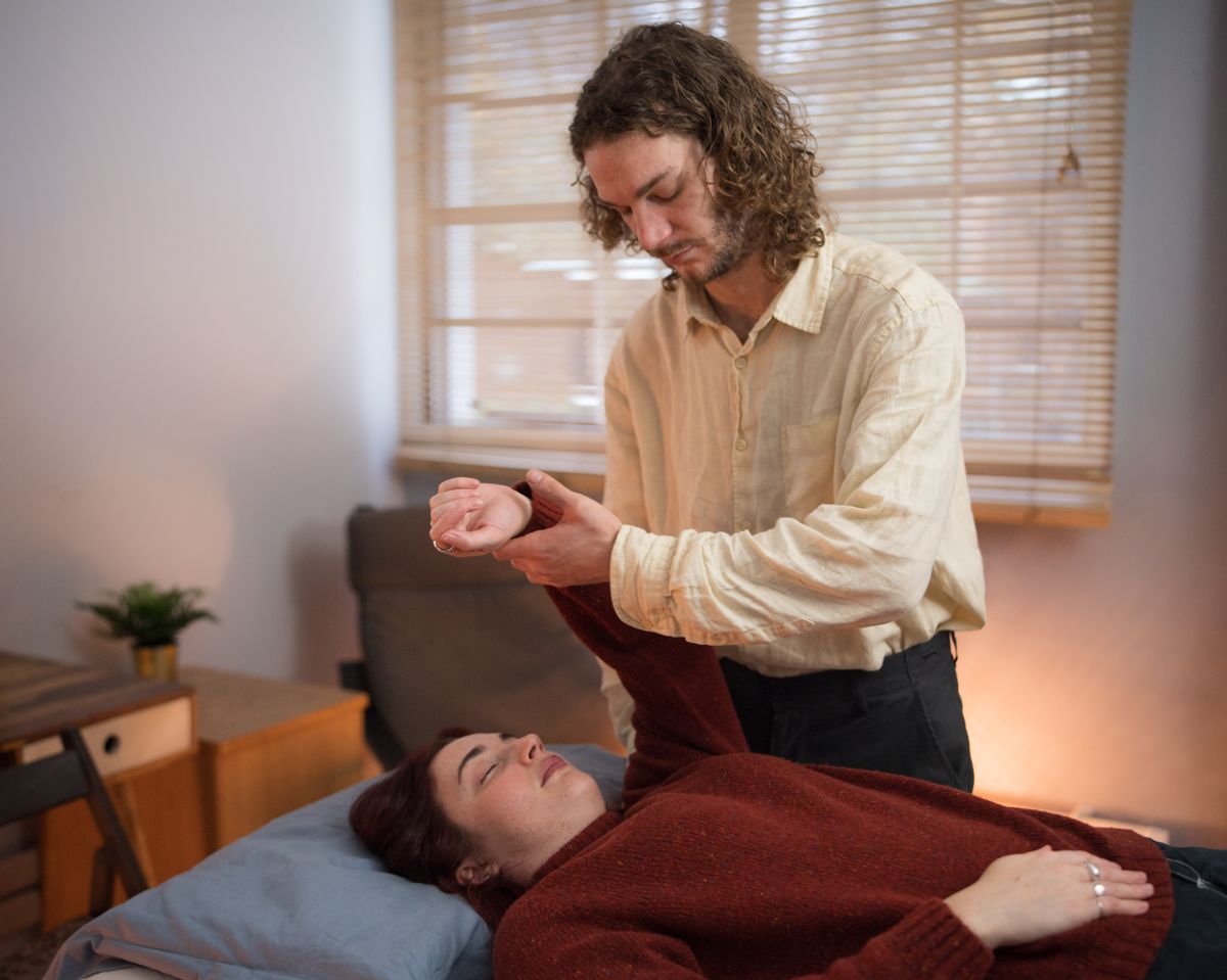 Fascial unwinding session London, therapist gently guiding arm movement